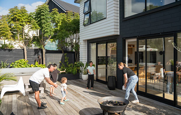 Maori family of five playing rugby game at backyard area of their home, parents teaching skills to their children to playa at weekend.