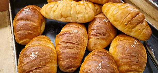 istock Freshly Baked Golden Brown Butter Rolls in Bakery Display Tray 2216579823