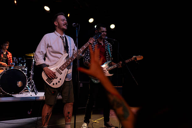 istock Pop rock band singing and playing instruments on an indoor stage during a live concert 2216581392