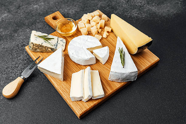 istock Cheese platter with various selections on a wooden cutting board 2216581554