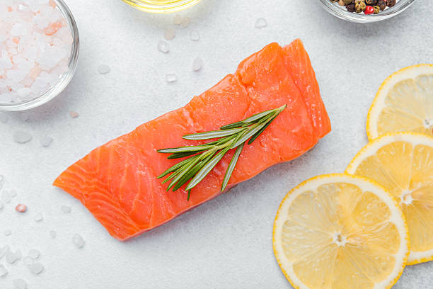 istock Fresh salmon fillet garnished with lemon slices and herbs in a kitchen setting 2216581623