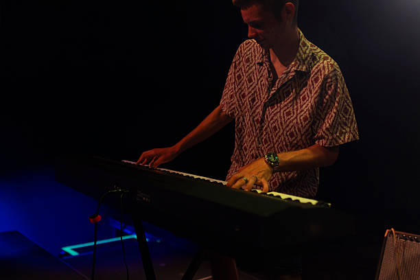 A musician playing an electronic keyboard. The image captures the focus and movement during a live musical performance