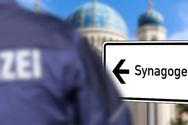 Ein deutscher Polizist steht vor einer Synagoge