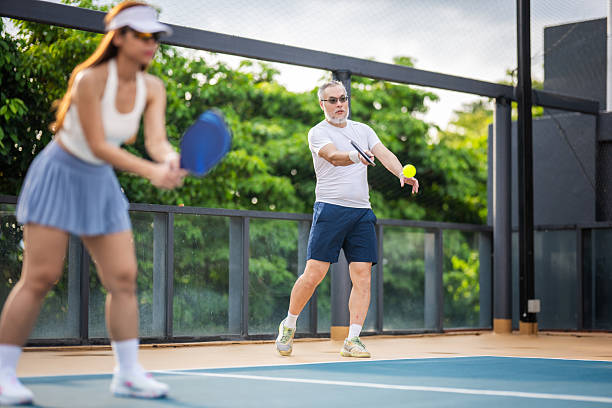 istock Focused and Ready: Serving the Ball in a Mixed Doubles Match Under the Open Sky 2216604325