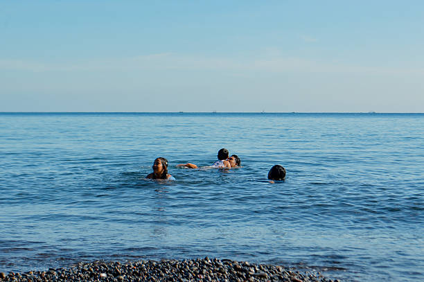 The entire family laughs and splashes together as they enjoy a second round of beach fun.