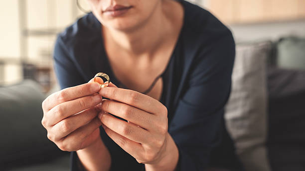 istock Woman takes off an wedding ring 2216606603