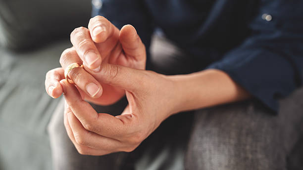 istock Woman takes off an wedding ring 2216606672