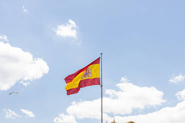 istock Spanish flag waving against a clear blue sky with fluffy clouds, symbolizing national pride and cultural identity in a vibrant atmosphere 2216609443