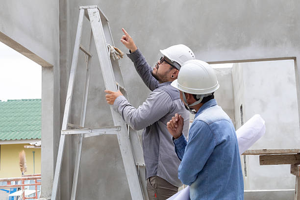 istock Young overweight engineering foreman climbing ladder inspect ceiling unfinished building or fixing error man work at construction site outdoors with Asian or Indian contractor man business partnership 2216611835