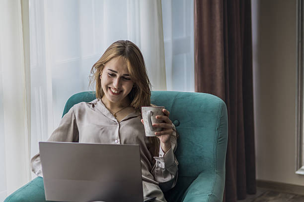 istock Emotions at work. Beautiful young woman feeling happy and satisfied after solving work problems on her laptop at home during weekend outside of working hours. 2216611939
