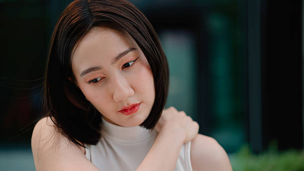 istock Young Asian woman massaging herself after feeling aching muscles from overwork. 2216612098