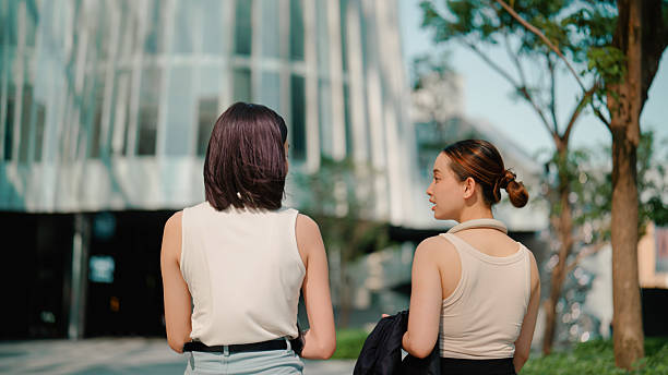 istock Two young Asian women talking casually while walking to work together. 2216612186