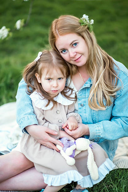 istock mother hugging her daughter in a blooming apple orchard in spring 2216612190