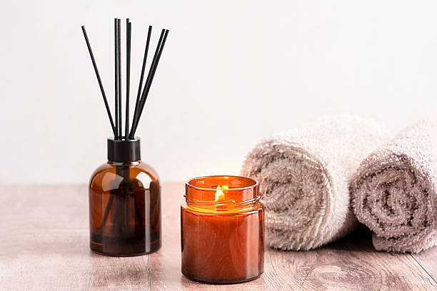 istock Relaxation and aromatherapy scene with glowing candle, reed diffuser and towels at spa 2216616928