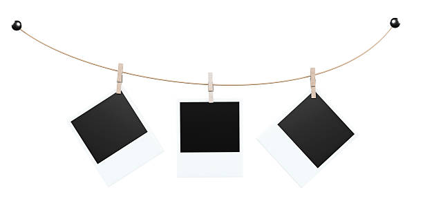 istock Three instant-photo mock-ups on curved gold cord with black end knobs; center frame straight, side frames tilted. 2216617229