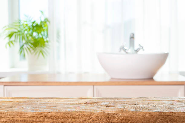 istock Wooden table top for product presentation on blurred bathroom window interior background 2216617355