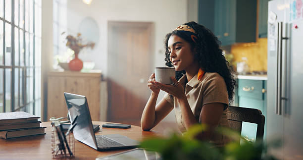 istock Woman, student and laptop with coffee in home for online course, e learning and development in morning. Girl, person and tea cup with computer for education, scholarship and class on web at house 2216618959
