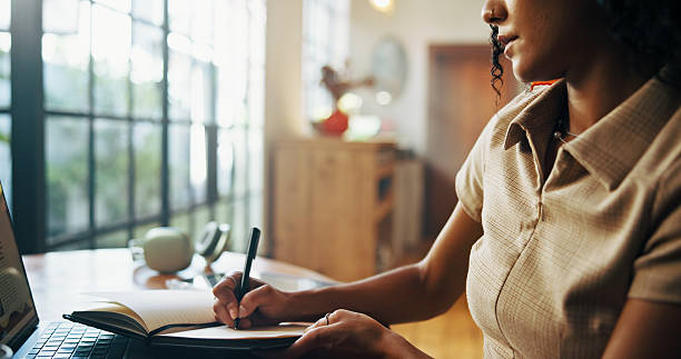 istock Hands, notebook and writing for remote work from home by laptop, planning and freelance job. Person, editor and story development with article for journal, review or newsletter in morning at house 2216618972