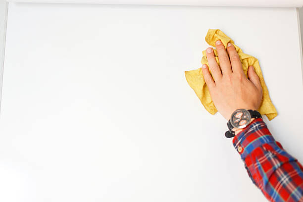 istock man's hand with a rag is cleaning a white board in the office 2216619267