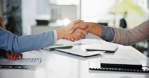 istock Meeting, handshake and business people with documents in office for interview, welcome or negotiation. Thank you, contract and support with shaking hands, form and consulting agreement or proposal 2216620695