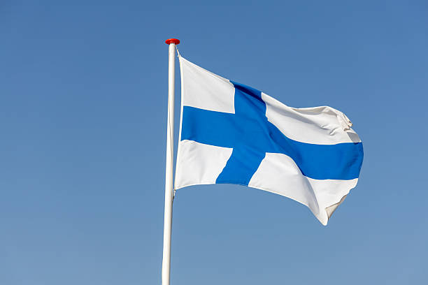 istock Finnish flag waving in the wind against a clear blue sky. 2216622402