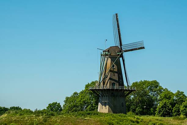 istock Traditional dutch windmill standing on green hill under blue sky 2216623846