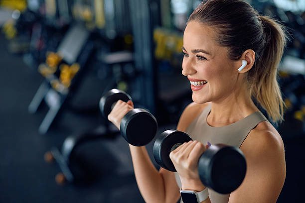 istock Happy athletic woman using dumbbells during gym workout. 2216625475