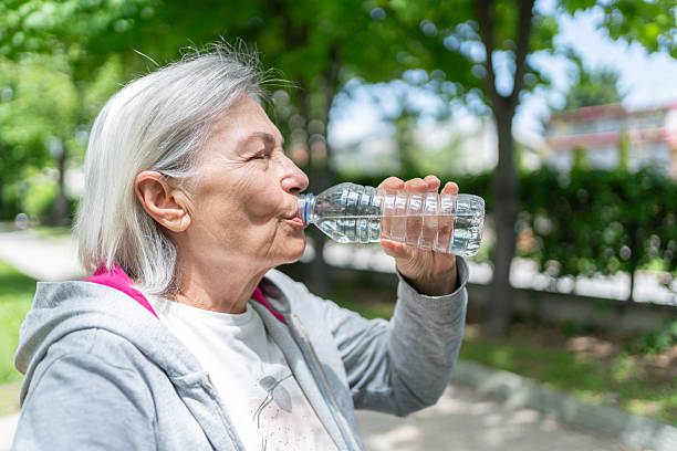 istock Senior Woman Drinking Water While Exercising Outdoors 2216626441