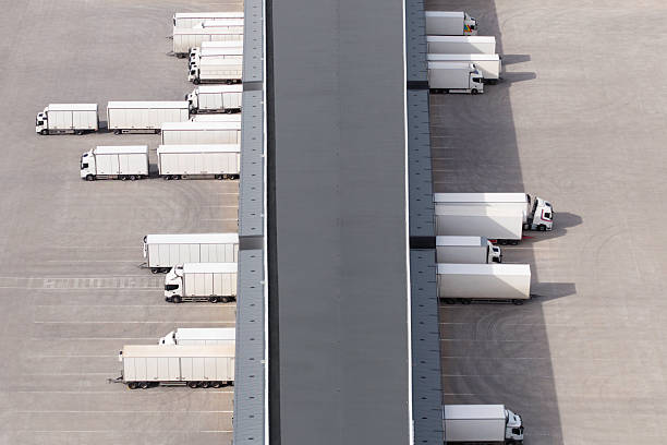 istock Trucks loading and unloading at the docks of a warehouse building 2216626494