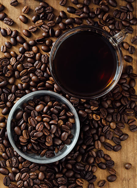 istock Aromatic Coffee Beans and Brewed Cup on Wooden Surface 2216626647