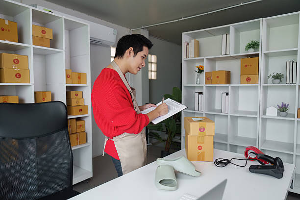Small business owner checking inventory and noting orders