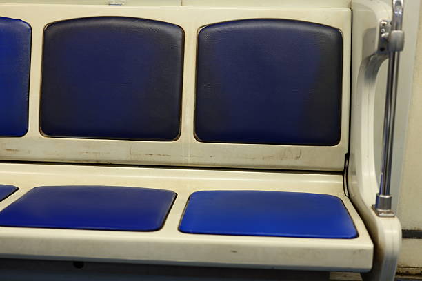 A closeup perspective of blue upholstery seats in a subway car, emphasizing the design of public transport