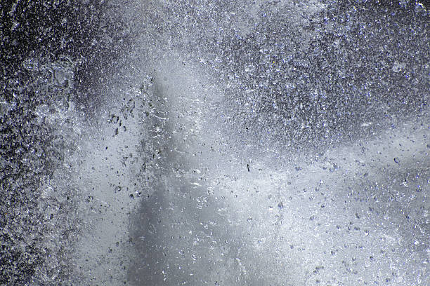 istock Splashing water droplets in motion against a grey background 2216635468