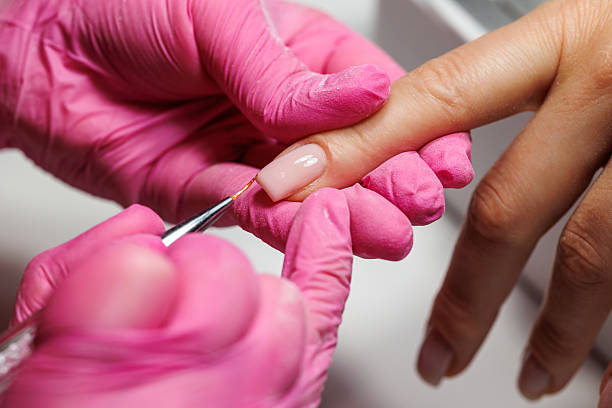istock Manicurist pushing back cuticles during nail care, french nails. 2216636280