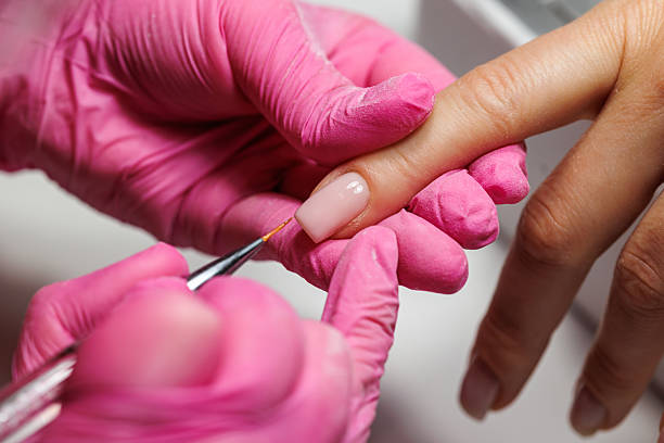 istock Manicurist pushing back cuticles during nail care, french nails. 2216636436