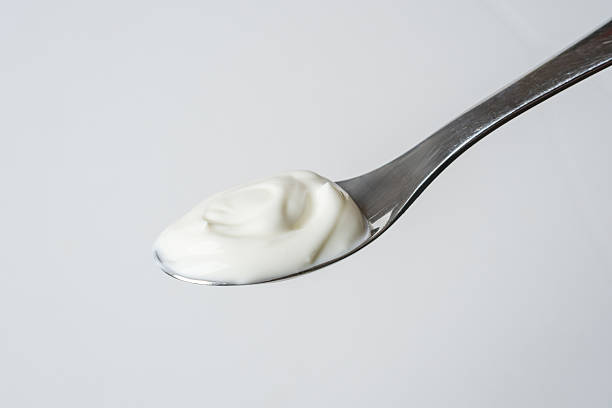 istock Spoonful of plain creamy yogurt on white background, minimal style 2216636685