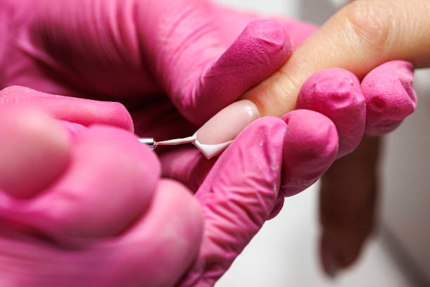 istock Manicurist pushing back cuticles during nail care, french nails. 2216637683