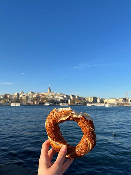 istock Hand Holding Turkish Simit with View of Istanbul Skyline 2216637695