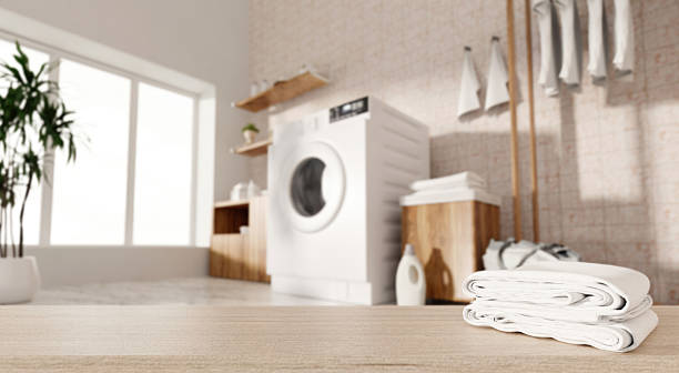 istock Contemporary laundry room with modern washing machine and neatly folded towels. 3D render illustration 2216639282