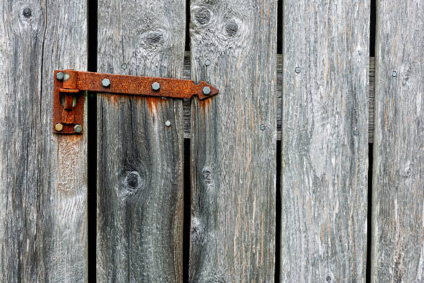 istock Rusty hinge on weathered wooden door in rural setting during daylight 2216639602