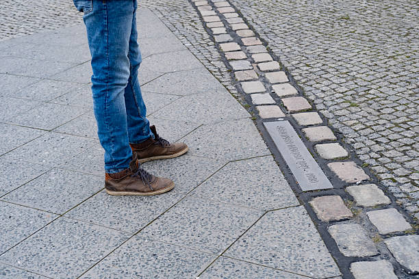 Ground marker indicating, Berlin Wall history, Remembering Cold War era, urban scene, historical landmark, street view, German history, Berlin