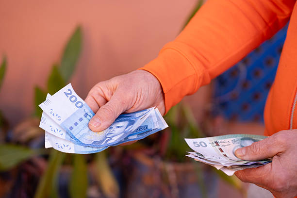 istock closeup male hands hold Moroccan dirham money, count paper dirham banknotes, concept cash payments, monetary savings, save for vacation, exchange and cashing currency 2216640575