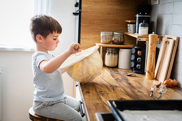 istock Little boy tasting whipped cream in kitchen 2216641279