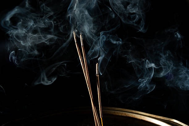 istock Three burning incense sticks with smoke on a black background. 2216642439