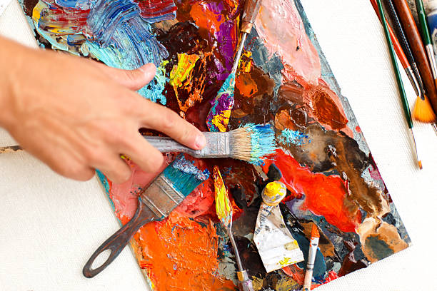 istock man's hand with a paint brush paints with oil paints 2216646089