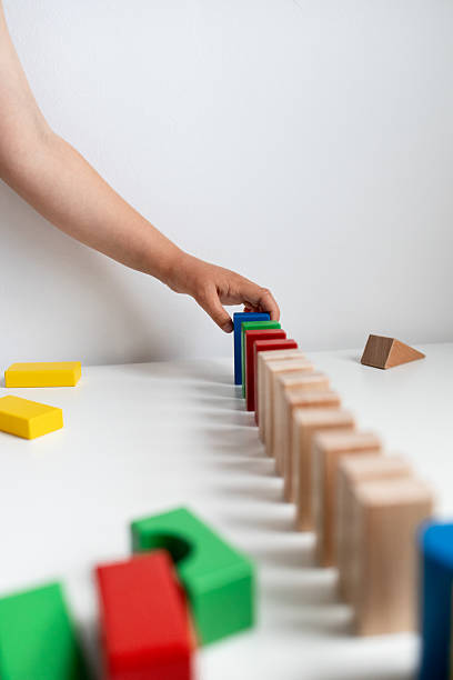 istock Child playing with colorful blocks in a creative domino setup 2216646479