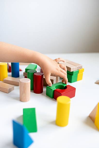 istock Child playing with colorful wooden blocks on white surface 2216646482
