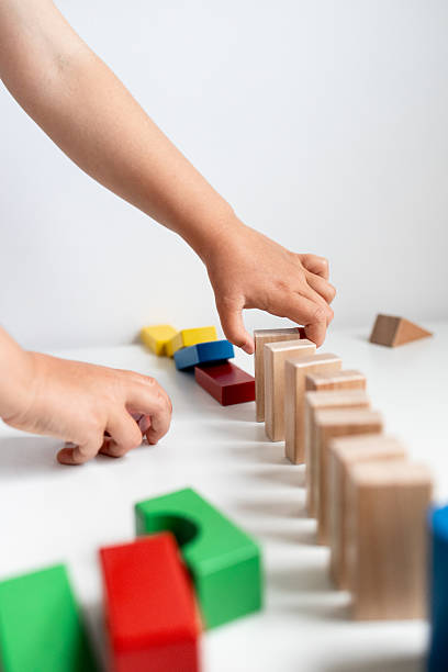 istock Child playing with colorful wooden blocks on white surface 2216646778