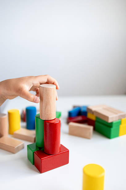 istock Child playing with colorful wooden blocks on white surface 2216646783