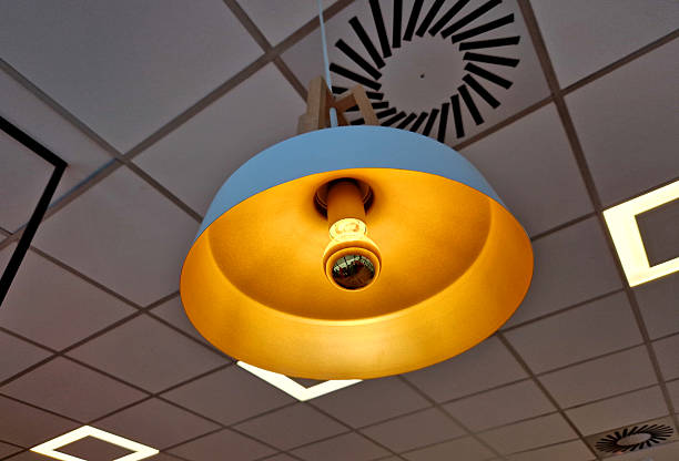 a lamp above the dining room table with gold lacquer and a lampshade bulb. it does not dazzle people, fan electric